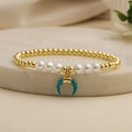 Beaded bracelet with gold metal spheres, white pearls, and blue horn moon charm - Blue Moon