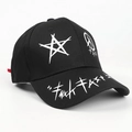 Dettaglio di un cappello nero in cotone con motivi graffiti bianchi e stampa a stella - Nero