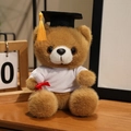 Brown graduation teddy bear in black cap and white shirt on a wooden table - White T-Shirt Style / Dark Brown