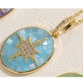 Makro-Detail des goldenen Oval-Anhängers mit Zirkonia-Stern und blauem Muschel-Mosaik - Blau