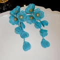 Detail of teal wire-mesh flower tassel earrings with sparkling cubic zirconia centers - Green