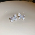 Macro shot of silver butterfly earrings with gradient crystals on a beige tray - 925 Sterling Silver Earring Post Silver Blue Ice Butterfly Style