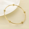 Detailed view of gold stainless steel bangle with five integrated beads on textured fabric - Inner Diameter 60mm / Single Ring / Gold