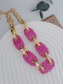 Gros plan d'un collier en or vintage avec des maillons en strass roses étincelants - Rose rouge
