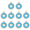 Detailed flat lay of ten light blue enamel heart pendants with gold-plated alloy borders - Blue