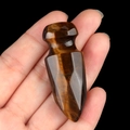 Polished tiger eye stone dagger figurine held in hand showing golden brown texture - Tiger's Eye