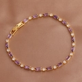 Detail of elegant gold bracelet featuring rectangular purple and white zircons on silk - Purple Bracelet