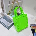 Mini fluorescent green PVC jelly handbag featuring stylish stud accents and a top handle - Fluorescent Green