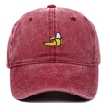 Close-up of embroidered yellow banana on burgundy washed cotton baseball cap texture - Burgundy