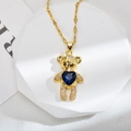 Dettaglio del ciondolo a forma di orsetto d'oro con cuore di zircone blu e micro-pavé - Blu