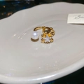 Detalle de anillo dorado con osito, perla y circonita cúbica en forma de estrella - Anillo Abierto de Perla Circonita Oso Estrella