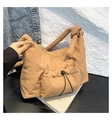 Macro view of khaki quilted nylon fabric with unique knot strap and drawstring detail - Brown
