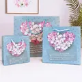 Three sky blue gift paper bags in different sizes featuring a floral heart and blue handles - Small (14*7*15cm) / Blue Heart Bouquet