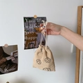 Close-up of beige corduroy drawstring pouch with an embroidered black smiley face - Khaki Smile Face