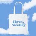 White canvas tote bag with blue Have A Nice Day slogan against a blue sky - Have A Nice Day / Blue Slogan