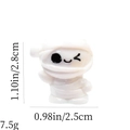 Macro shot of miniature white mummy figurine with specific size and weight measurements - Winking Mummy
