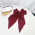 Close-up of wine red chiffon bow hair clip with long ribbons on a white surface - Burgundy