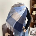 Sciarpa a quadri blu e grigi effetto cashmere con lunghe frange su un manichino - Quadri Grigio Blu