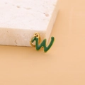Green enamel letter W pendant in gold finish stainless steel on marble surface - Enamel Letter-W