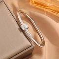Dettaglio macro del bracciale argento con design a triplo anello e pavé di zirconi - Argento