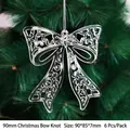 Pack of six silver 90mm hollow Christmas bow ornaments hanging on a festive tree branch - 90mm Christmas Bow