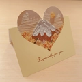 Detailed view of 3D heart-shaped greeting card with oil painting house design on desk - Mount Fuji