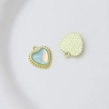 Macro detail of heart-shaped charm with blue faux opal inlay and golden beaded edge - Style 14