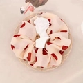 Beige organza scrunchie with red polka dots on a woven tray with a small plaster statue - Wine Red Heart