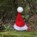 Mini fermaglio per capelli cappello di Babbo Natale rosso su sfondo di aghi di pino - Cappello Dritto / Cappello Rosso di Natale