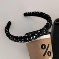 Detailopname van een zwarte pluche haarband met zilveren lovertjes op een koffiekopje - Zwart