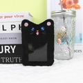 Detalle de porta tarjetas de gato en peluche negro con bordado y ventana de PVC transparente - Gato Negro