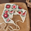 Detail of hand-crocheted floral headscarf with pink flowers on a rustic wooden tray - Dark Plum Pink Daisy (25026)
