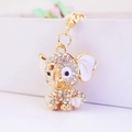 Golden elephant keychain with white rhinestones and enamel details on white background - White