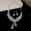 Dettaglio parure di gioielli argento con cristalli a goccia e strass scintillanti - Argento-Bianco