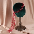 Detailed view of red beaded bridal hair band with tassels on velvet mannequin - Red