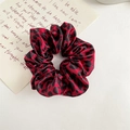 Detailansicht eines Satin-Haargummis mit rot-schwarzem Leopardenmuster und Seidenglanz - Rotes Leopardenmuster