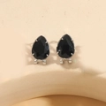 Elegant black teardrop crystal earrings with silver claw setting on textured beige background - Black Zirconia (Silver)
