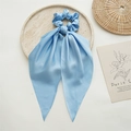 Elegant light blue satin scrunchie with long ribbons on a textured decorative tray - Light Green