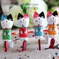 Set mit vier bunten handbemalten nordischen Holz-Angelkatzen-Figuren auf weißer Bank - 4er-Set