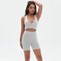 Dettaglio completo del set yoga grigio senza cuciture con reggiseno incrociato e pantaloncini - Bianco Chiaro di Luna