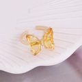 Close-up of a butterfly ring featuring yellow crystal wings and a golden adjustable band - One Size / Yellow
