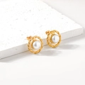 Orecchini a treccia dorati con perla bianca su espositore in pietra naturale - Oro