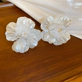 Pendientes de flores de acrílico blanco con perla sobre mesa de madera y seda - Flor Blanca con Aguja de Plata