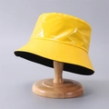 Detalle de un sombrero de pescador de cuero PU amarillo brillante en soporte - Talla única / Amarillo