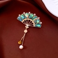 Detalle macro del broche de abanico vintage con nácar de abulón y colgante de Fu - Dorado con Verde (Chapado en Oro Real)