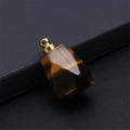 Polygonal tiger eye stone perfume bottle pendant with gold metal clasp on black background - Tiger's Eye
