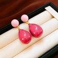 Dettaglio di orecchini a goccia in resina rosa con finiture dorate in scatola regalo - Rosa e Magenta