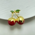 Detail of cherry brooch featuring red enamel fruits and green crystal leaves on gold stem - Style 15 Wavy Top Red Cherry