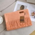 Warm orange soft cashmere-feel scarf with tassels folded on a sofa with cozy accessories - 15# Pink Orange