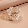 Gros plan du motif floral creux en argent mat sur un bracelet large style dentelle - Style de fleur creuse en argent